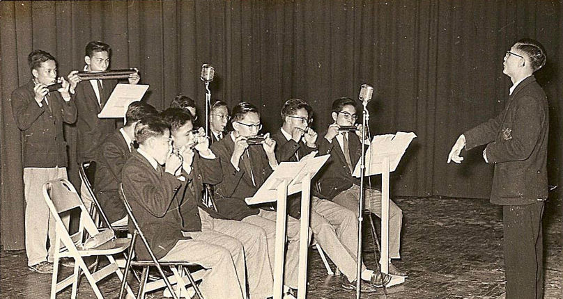 趙汝祥指揮口琴隊藍隊於一九五六年在母校大禮堂演出（區作燊提供）